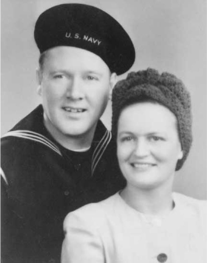 U.S. Navy sailor poses with a smiling woman, both dressed in mid-20th century attire, symbolizing love and support in wartime.
