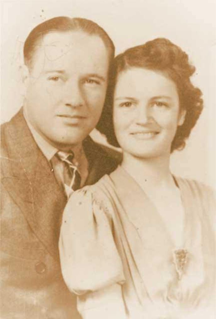 A vintage sepia-toned photograph of a couple, smiling closely together, showcasing 1940s fashion and hairstyles.