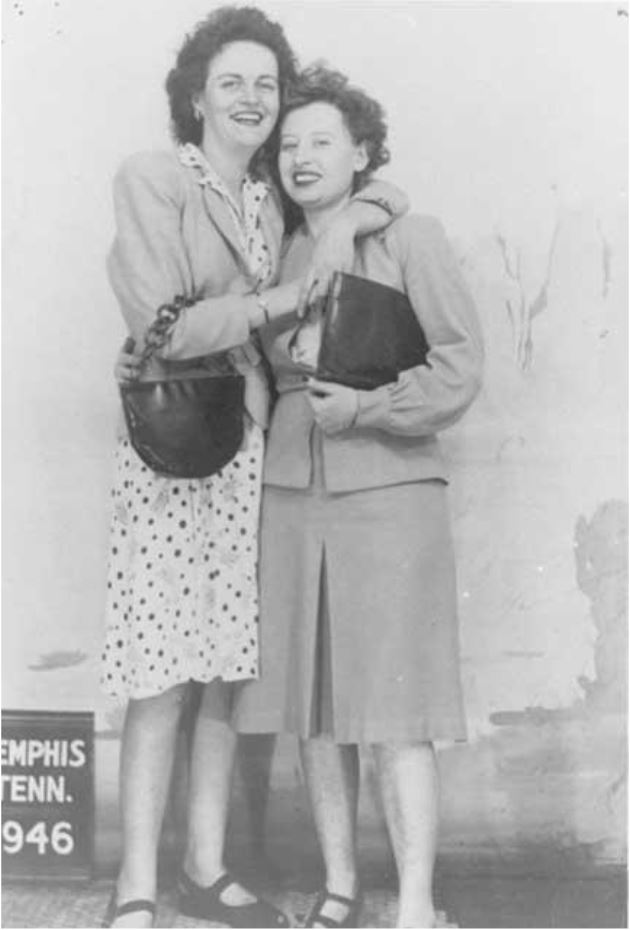 Two women pose together, smiling and embracing, wearing 1940s fashion. A sign reads "Memphis, Tenn. 1946," capturing a moment in time.